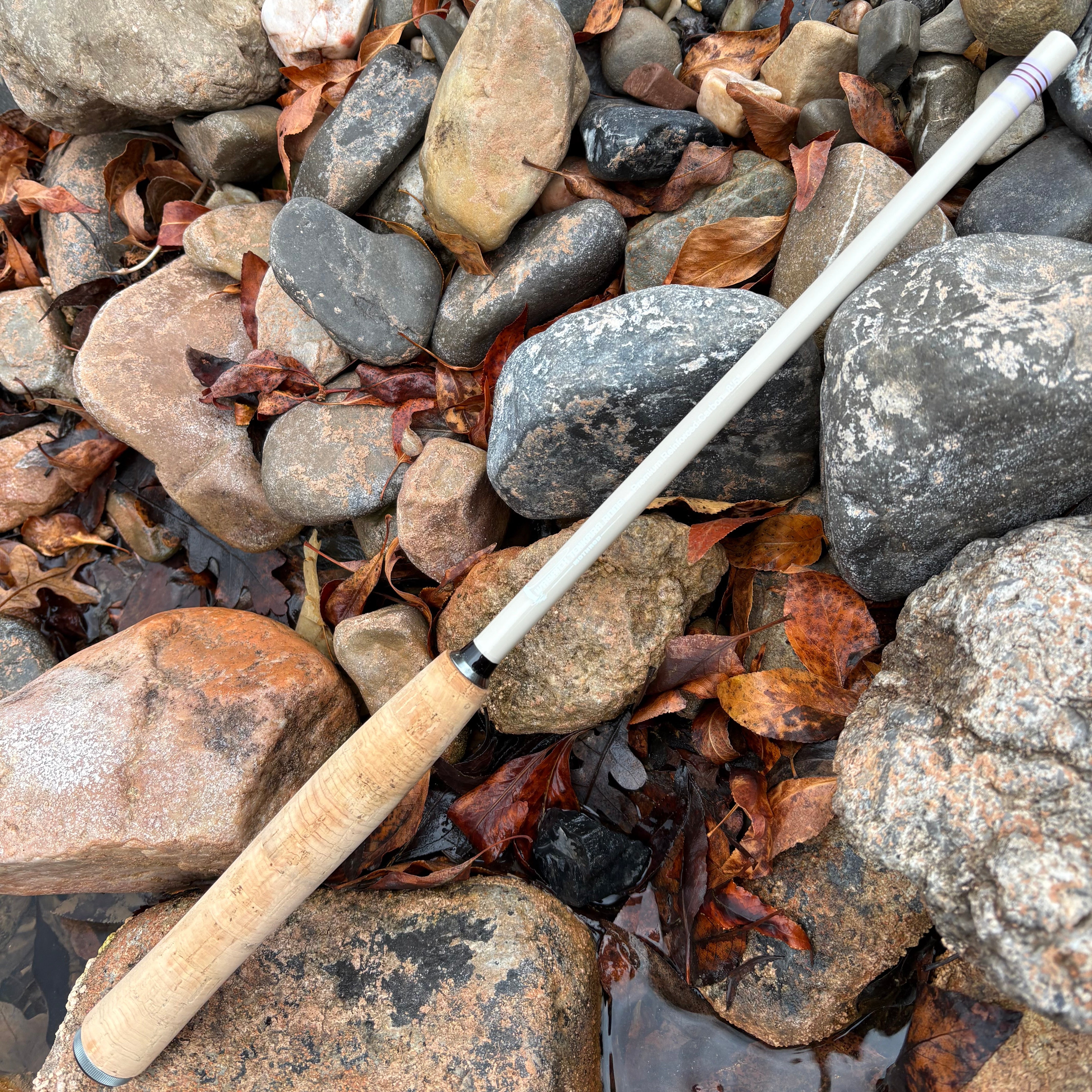 Fishing rod lying on a bed of rocks and pebbles