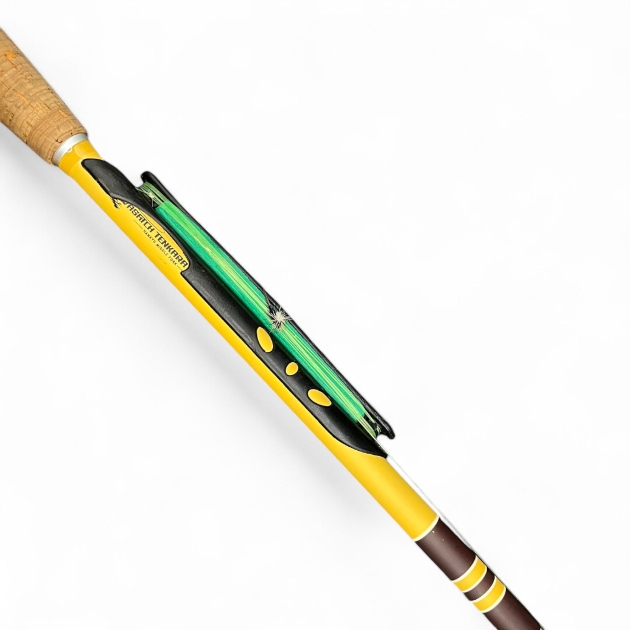 Close-up of a yellow Wasatch Tenkara Rods - Hankyu Middle Fork rod featuring an snap-on black line holder with a green fishing line coiled neatly, showcasing its sleek and functional design.