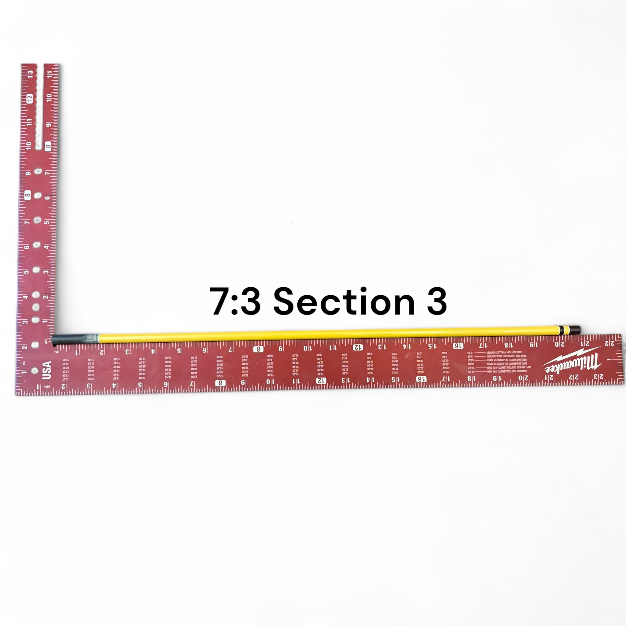 Section 3 of the Middle Fork 7:3 Tenkara Rod by Wasatch Tenkara Rods, displayed with a red measuring square for scale. The rod features yellow carbon fiber construction with brown accent bands.